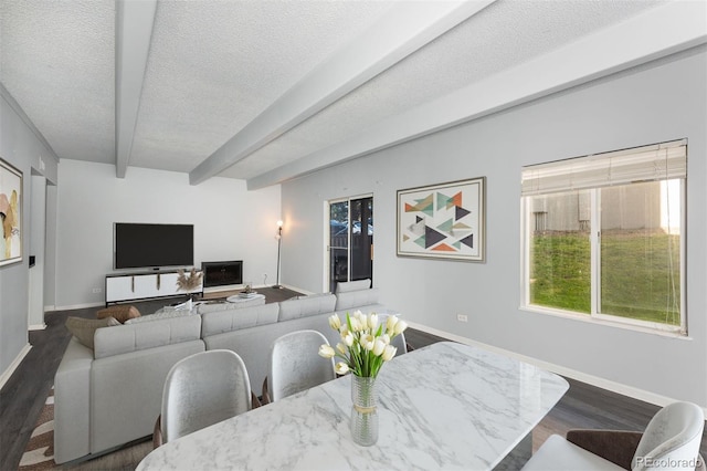 dining space with beamed ceiling, dark wood-type flooring, and a textured ceiling