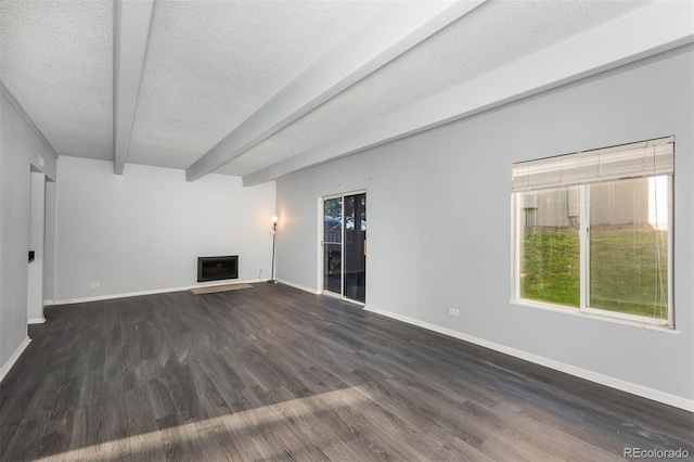 unfurnished living room with beamed ceiling, dark hardwood / wood-style flooring, and a textured ceiling