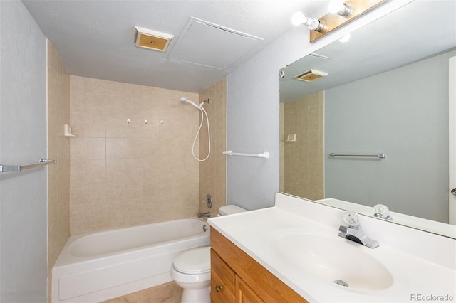 full bathroom featuring tiled shower / bath, vanity, toilet, and a textured ceiling