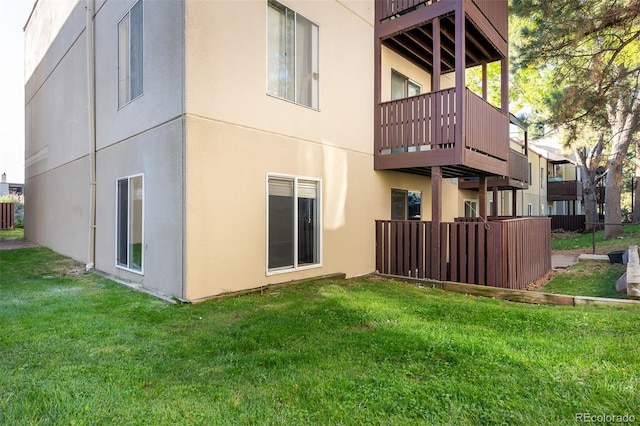 back of property with a balcony and a lawn