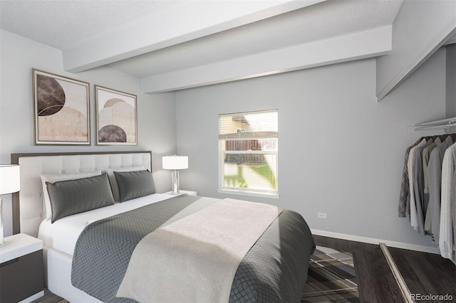 bedroom featuring a textured ceiling and dark hardwood / wood-style flooring