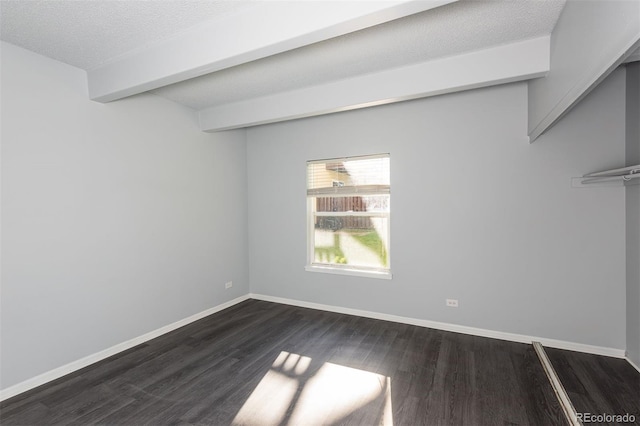 empty room with a textured ceiling and dark hardwood / wood-style flooring