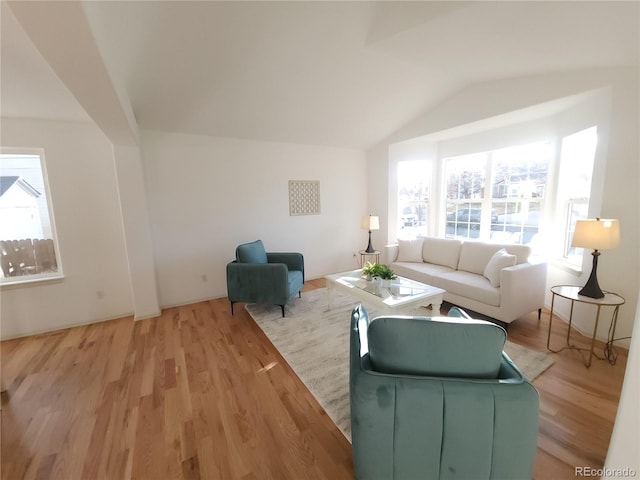 living room featuring lofted ceiling and light wood-style floors