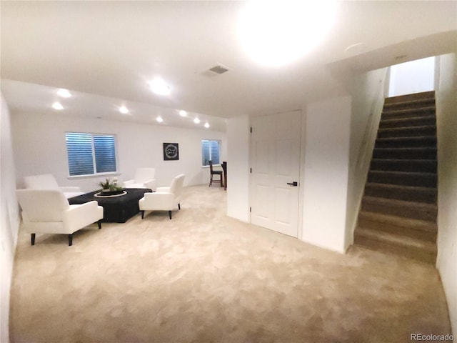 sitting room featuring light carpet, stairway, and visible vents