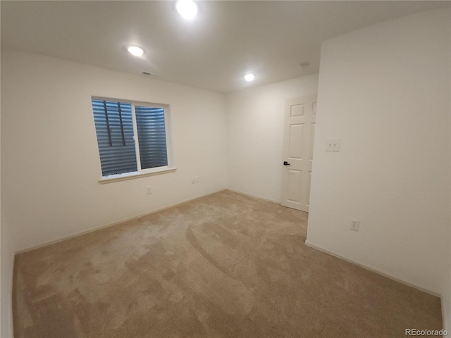 carpeted spare room featuring visible vents