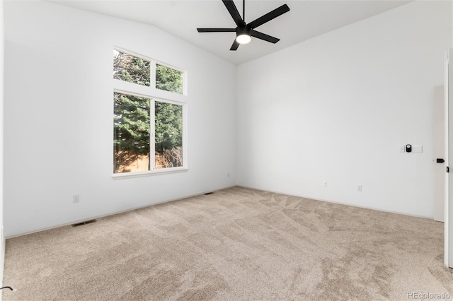 spare room with visible vents, lofted ceiling, carpet, and a ceiling fan