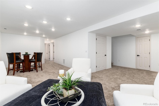 living area with recessed lighting and light carpet