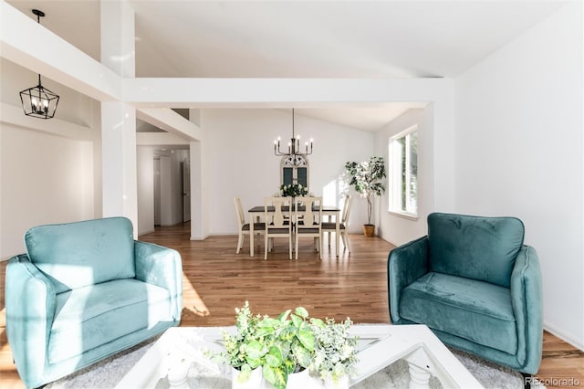 living room featuring lofted ceiling, a notable chandelier, and wood finished floors