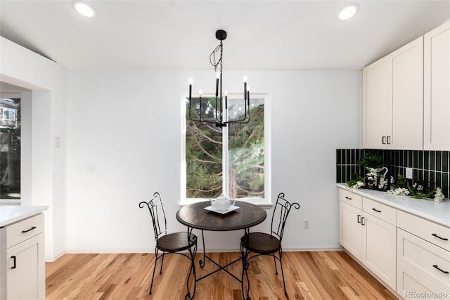 dining area featuring an inviting chandelier, light wood-style flooring, and plenty of natural light