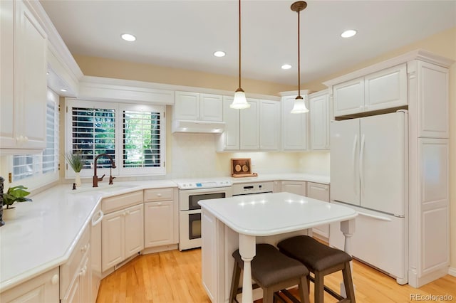 5530 Racquet Ln, Boulder, CO 80303 - kitchen featuring white appliances, light wood-style floors, a kitchen island, light countertops, and recessed lighting