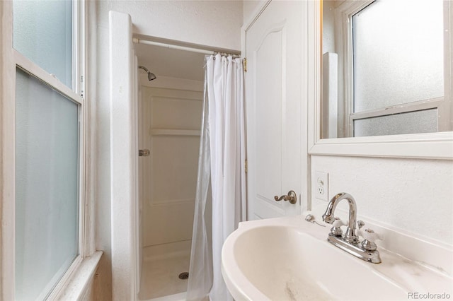 bathroom with walk in shower and sink