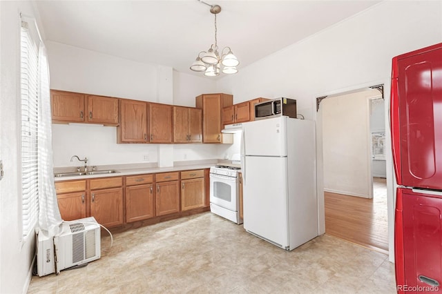 kitchen with decorative light fixtures, white appliances, sink, and an inviting chandelier