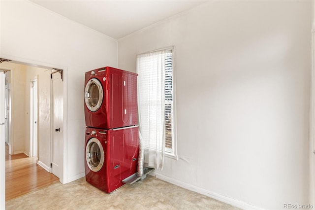 clothes washing area featuring stacked washing maching and dryer