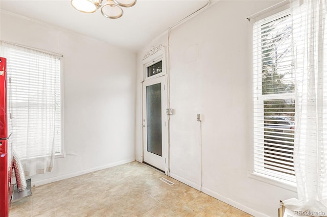 unfurnished room featuring an inviting chandelier