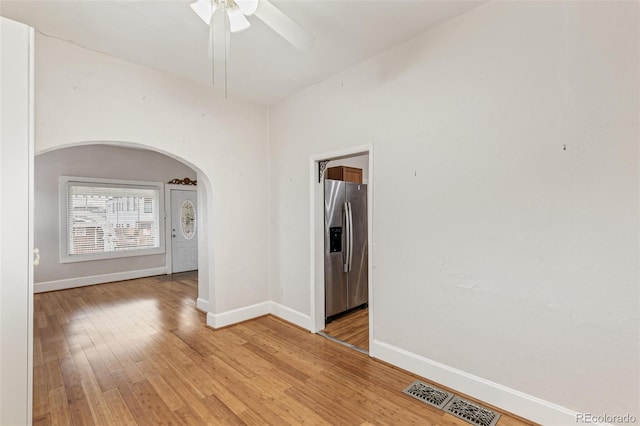 empty room with hardwood / wood-style floors and ceiling fan