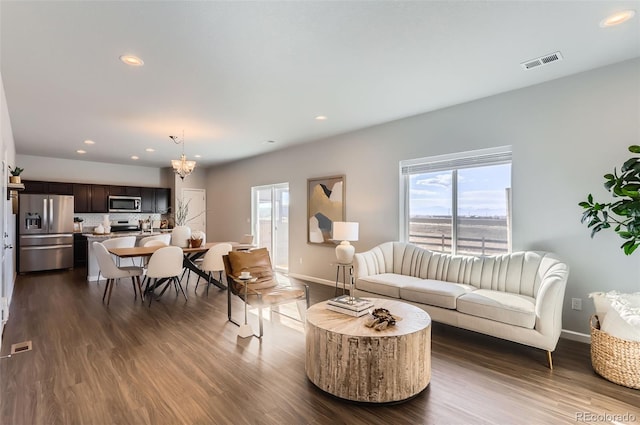 living room featuring dark wood-type flooring and a notable chandelier