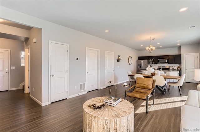 living room with dark wood-type flooring and a chandelier