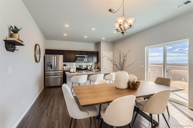 dining room featuring an inviting chandelier and dark hardwood / wood-style flooring