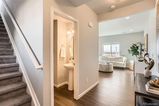 stairway featuring hardwood / wood-style flooring and sink