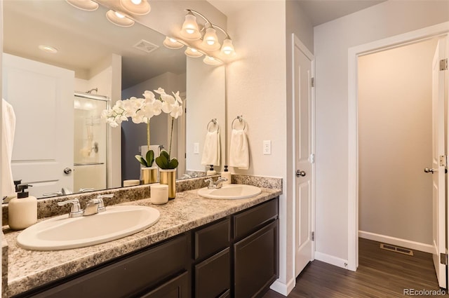 bathroom with a shower with door, vanity, and hardwood / wood-style floors