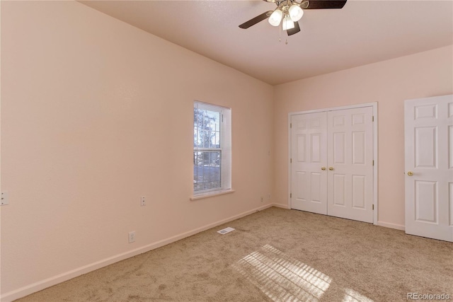 unfurnished bedroom featuring ceiling fan, a closet, and light carpet