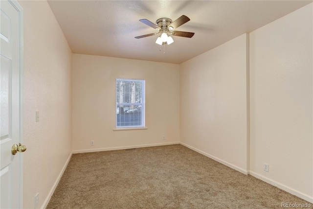 unfurnished room with ceiling fan and carpet