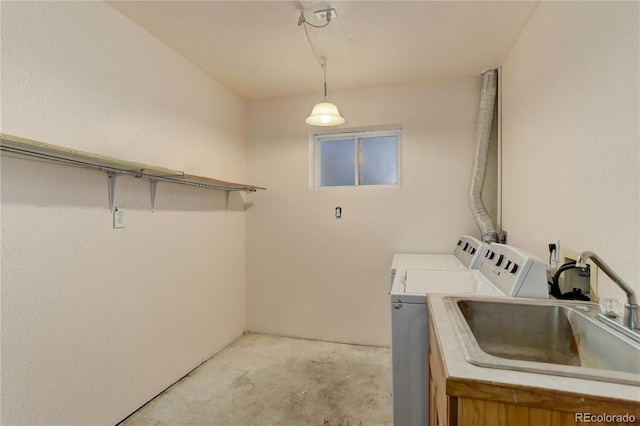 clothes washing area featuring sink and washer and clothes dryer