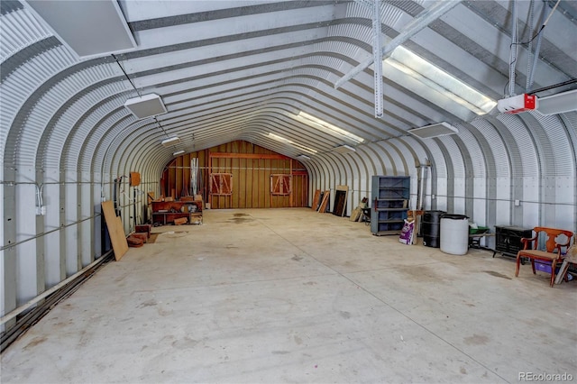 miscellaneous room with concrete flooring and vaulted ceiling