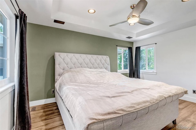 10609 Abilene St, Commerce City, CO 80022 - bedroom featuring a tray ceiling, light wood-type flooring, recessed lighting, and a ceiling fan