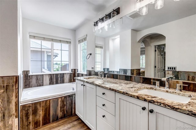 10609 Abilene St, Commerce City, CO 80022 - full bath with double vanity, a garden tub, and wood finished floors