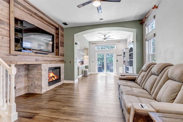 10609 Abilene St, Commerce City, CO 80022 - living area with a ceiling fan, arched walkways, hardwood / wood-style floors, and plenty of natural light