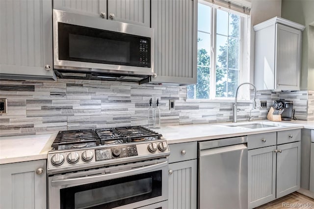 10609 Abilene St, Commerce City, CO 80022 - kitchen featuring appliances with stainless steel finishes, gray cabinetry, tasteful backsplash, and plenty of natural light