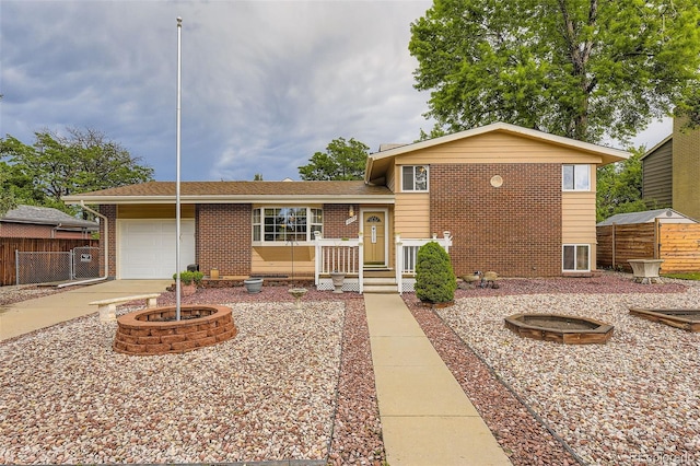 6072 Pierson Ct, Arvada, CO 80004 - tri-level home featuring brick siding, a garage, and an outdoor fire pit