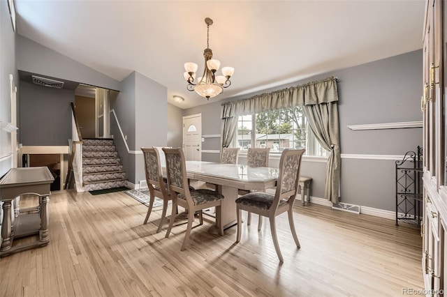 6072 Pierson Ct, Arvada, CO 80004 - dining area with a chandelier, vaulted ceiling, light wood-type flooring, and stairway