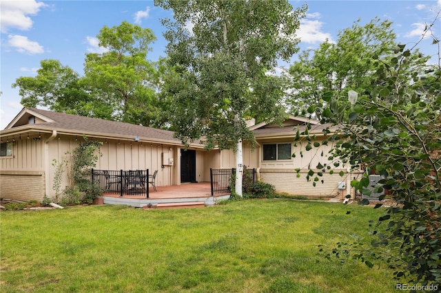 3298 S Krameria St, Denver, CO 80222 - rear view of property featuring board and batten siding, a deck, a lawn, brick siding, and a shingled roof