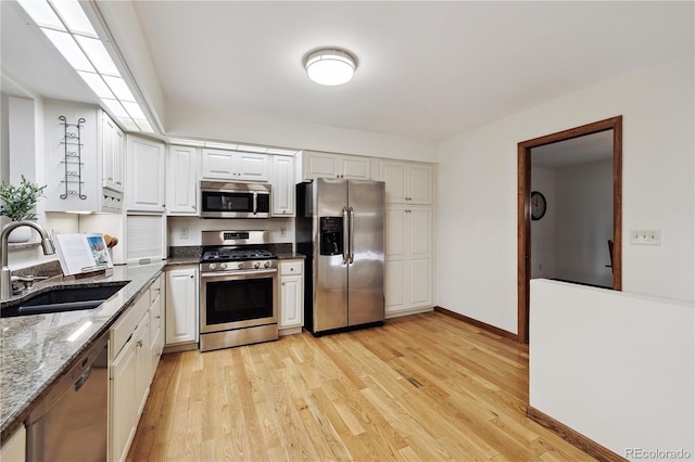 3298 S Krameria St, Denver, CO 80222 - kitchen featuring appliances with stainless steel finishes, light wood-style flooring, white cabinets, and dark stone countertops