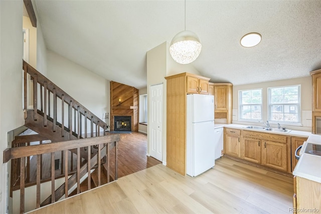 9642 W Chatfield Ave Unit A, Littleton, CO 80128 - kitchen with white appliances, lofted ceiling, a large fireplace, light wood-type flooring, and light countertops
