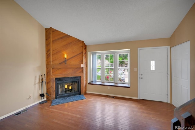 9642 W Chatfield Ave Unit A, Littleton, CO 80128 - unfurnished living room with a large fireplace, hardwood / wood-style floors, and lofted ceiling