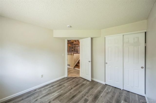 9642 W Chatfield Ave Unit A, Littleton, CO 80128 - unfurnished bedroom featuring a closet, wood finished floors, and a textured ceiling