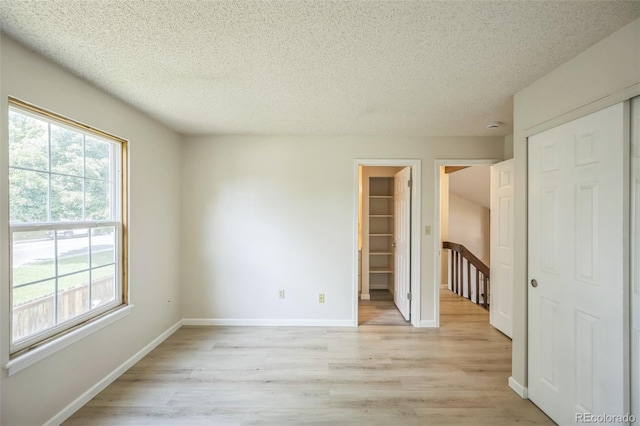 9642 W Chatfield Ave Unit A, Littleton, CO 80128 - unfurnished room featuring a textured ceiling, light wood-style floors, and a smoke detector