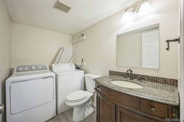 9642 W Chatfield Ave Unit A, Littleton, CO 80128 - half bathroom featuring washer and clothes dryer, vanity, and wood finished floors