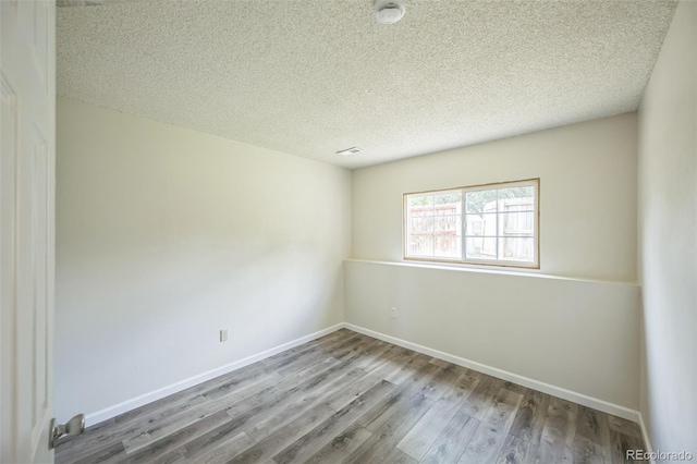 9642 W Chatfield Ave Unit A, Littleton, CO 80128 - spare room with wood finished floors, a smoke detector, and a textured ceiling