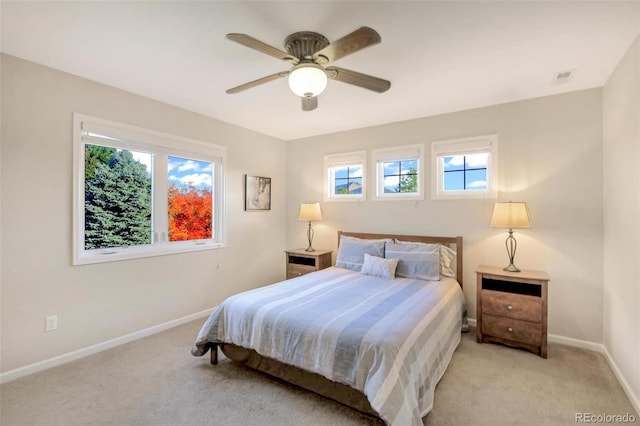 bedroom with light colored carpet, multiple windows, and baseboards