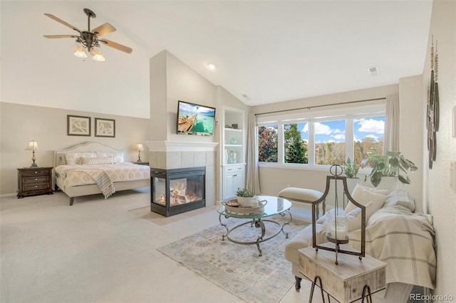 carpeted living room featuring a ceiling fan, visible vents, built in features, vaulted ceiling, and a fireplace