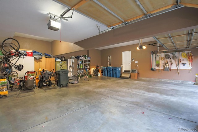 garage featuring stainless steel fridge with ice dispenser and a garage door opener