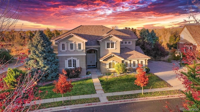 view of front of house with concrete driveway, stucco siding, and a tile roof