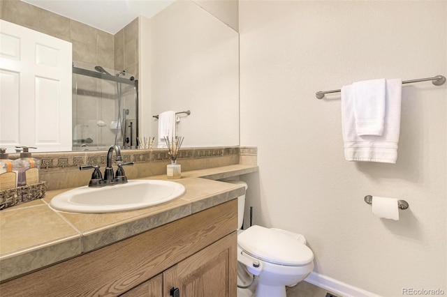 full bathroom with a stall shower, baseboards, vanity, and toilet
