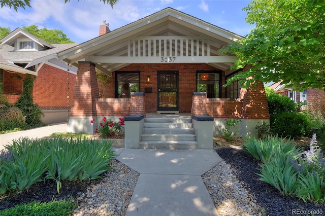 3237 N Josephine St, Denver, CO 80205 - view of front of house featuring brick siding, a porch, and a chimney