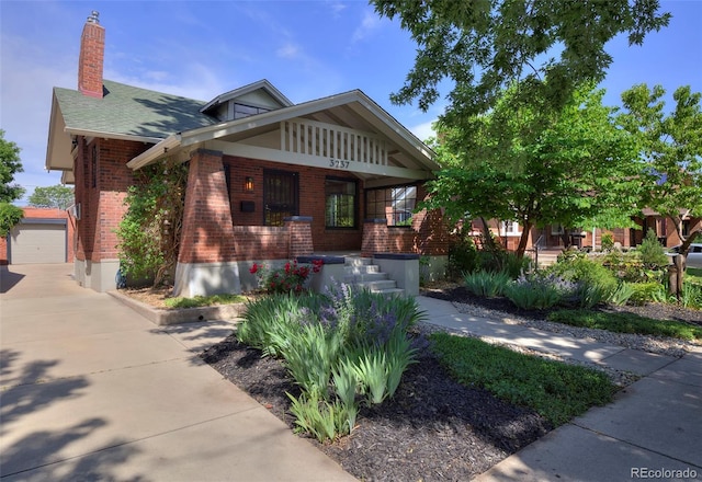 3237 N Josephine St, Denver, CO 80205 - view of front of property featuring brick siding, a porch, a chimney, an outdoor structure, and driveway