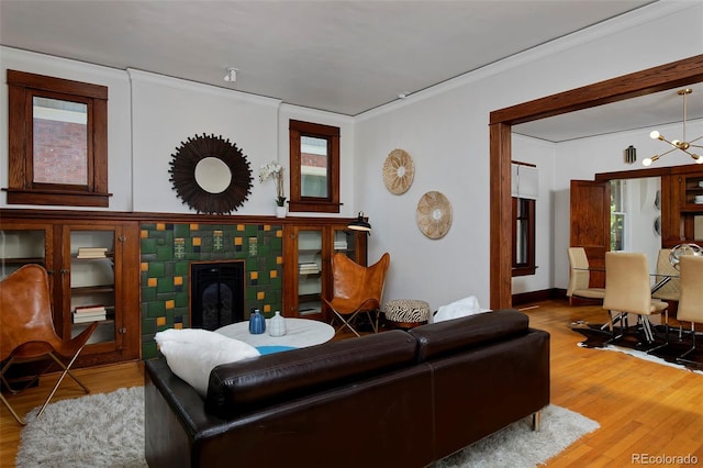 3237 N Josephine St, Denver, CO 80205 - living room with ornamental molding, wood finished floors, a chandelier, a tiled fireplace, and healthy amount of natural light